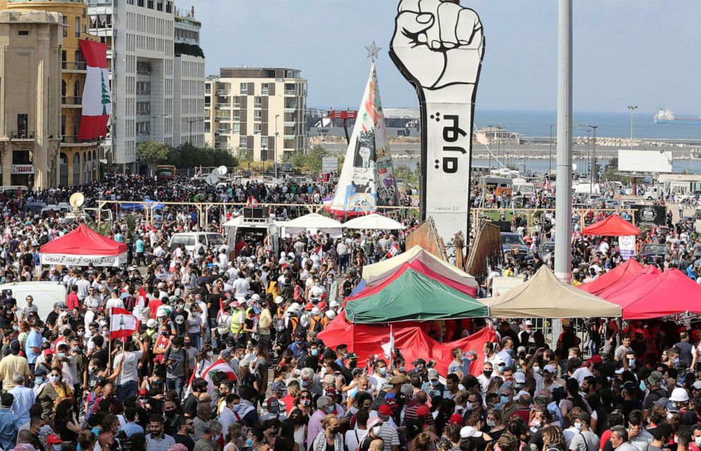 PHOTO: Lebanese people gather around a fist-shaped banner reading 'Revolution' during a protest in the aftermath of a devastating explosion, in Beirut, Aug. 8, 2020.