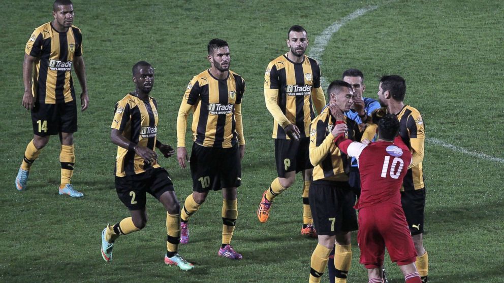 PHOTO: A player from Bnei Sakhnin, the only Arab team in the Israeli Premier league, scuffles with a player from Beitar Jerusalem at the Doha Stadium in the northern Arab-Israeli town of Sakhnin on Nov. 23, 2014.