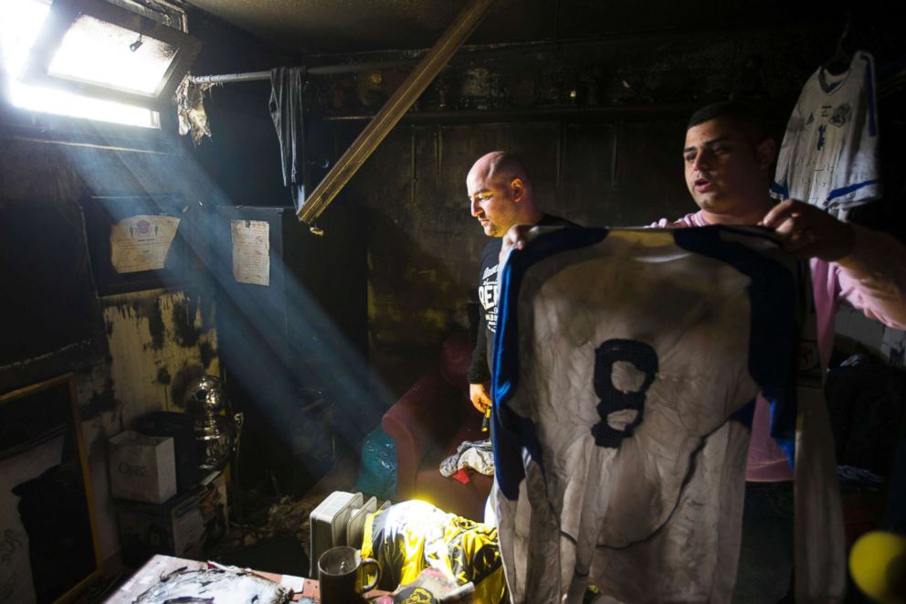 PHOTO: An employee of Beitar Jerusalem holds up a shirt that was damaged along with other items in a suspected arson attack at the soccer team's club house in Jerusalem, Feb. 8, 2013.