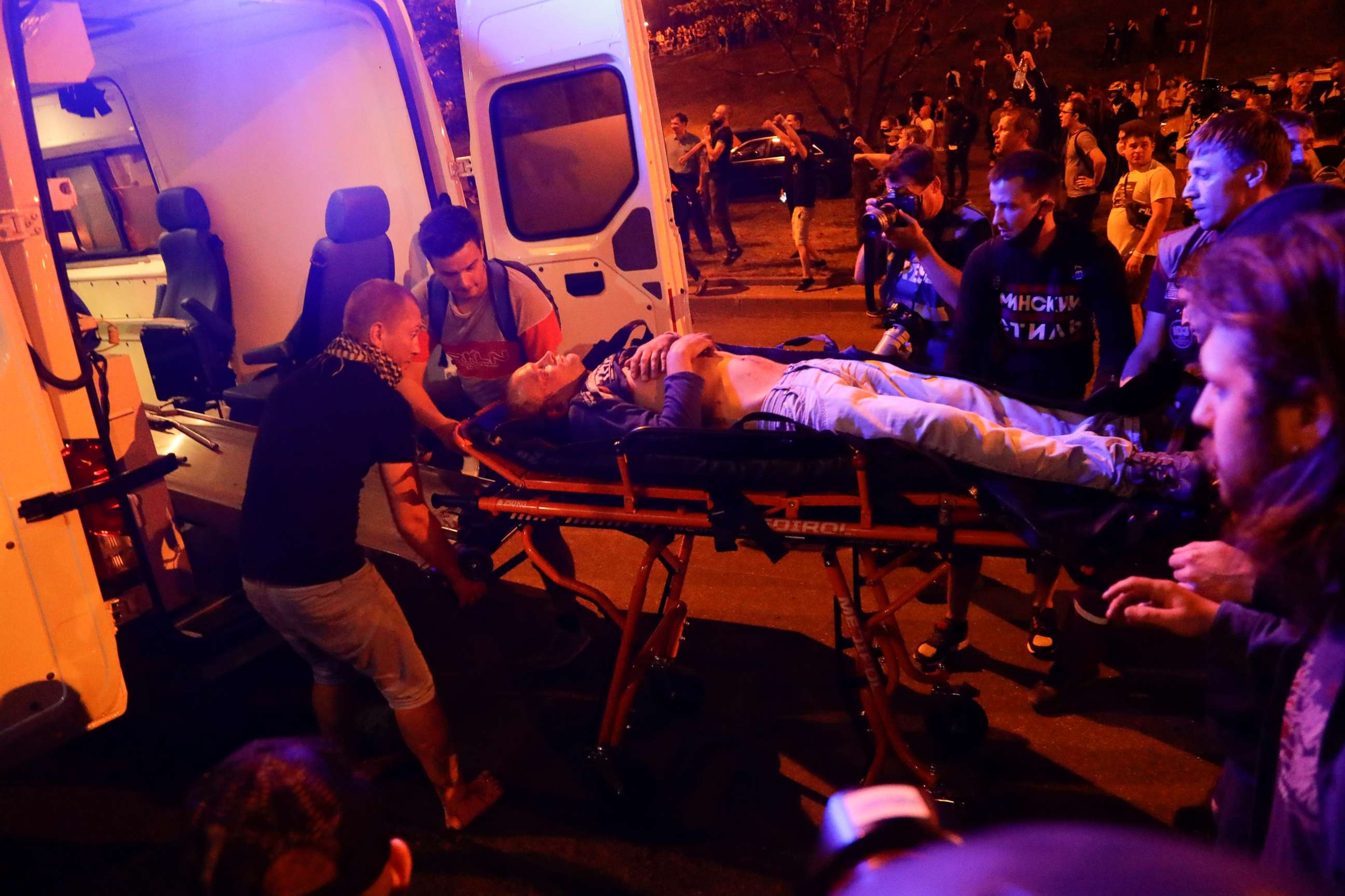 PHOTO: Protesters help paramedics to carry a wounded person into an ambulance after clashes with police in Minsk, Belarus, Sunday, Aug. 9, 2020.