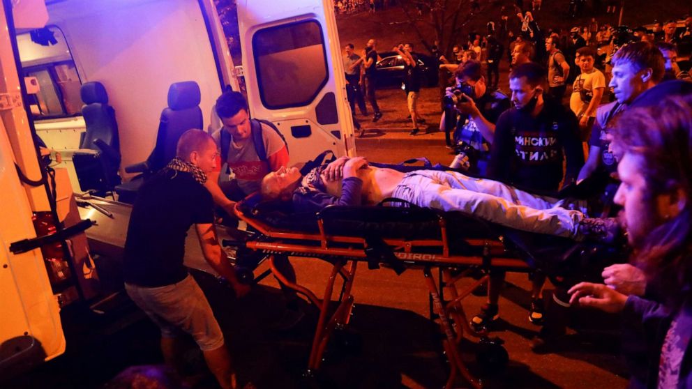 PHOTO: Protesters help paramedics to carry a wounded person into an ambulance after clashes with police in Minsk, Belarus, Sunday, Aug. 9, 2020.