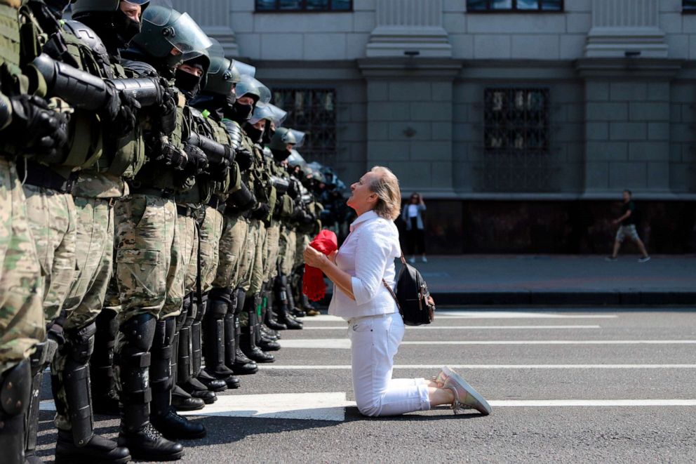 PHOTO: A woman kneels in front of a riot police line as they block Belarusian opposition supporters rally in the center of Minsk, Belarus, Aug. 30, 2020.