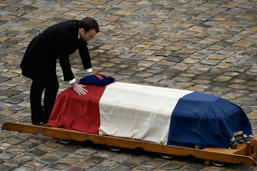 PHOTO: French President Emmanuel Macron places his hands on the flag-draped coffin of Lt. Colonel Arnaud Beltrame after awarding him posthumously with the Legion of Honour during a national ceremony on March 28, 2018 at the Hotel des Invalides in Paris.