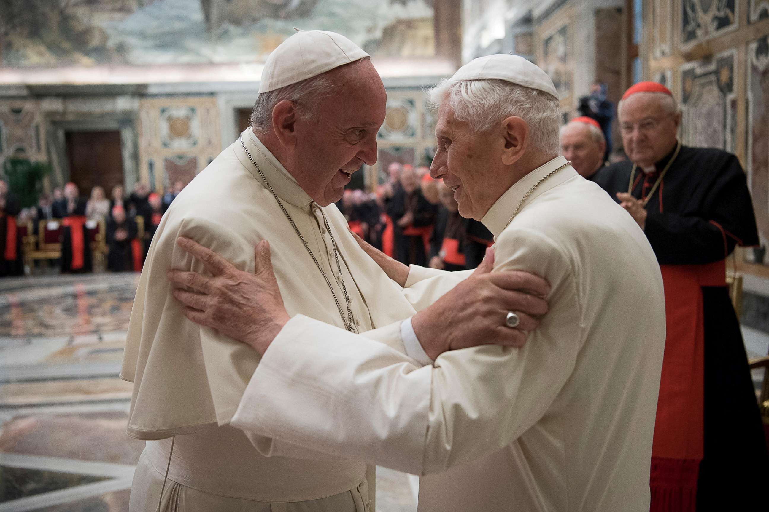 FILE PHOTO: Former pope Benedict, right, is greeted by Pope Francis during a ceremony to mark his 65th anniversary of ordination to the priesthood at the Vatican, on June 28, 2016.
