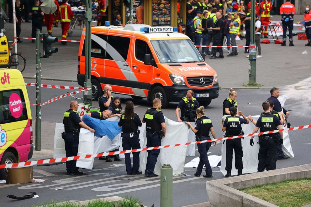 PHOTO: Police cover a corpse after a car crashed into a group of people before hitting a storefront at Tauentzienstrasse in Berlin, June 8, 2022.