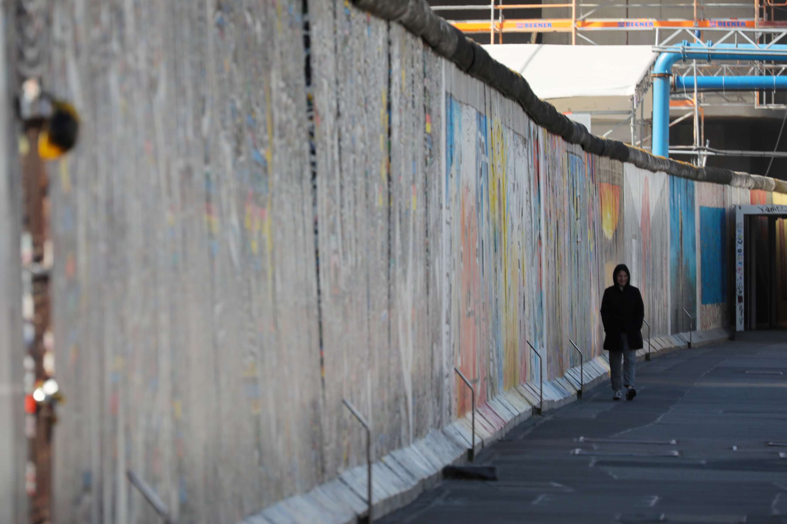 PHOTO: A lone person walks alongside the Berlin Wall East Side Gallery as the spread of the coronavirus disease continues, in Berlin, March 22, 2020.