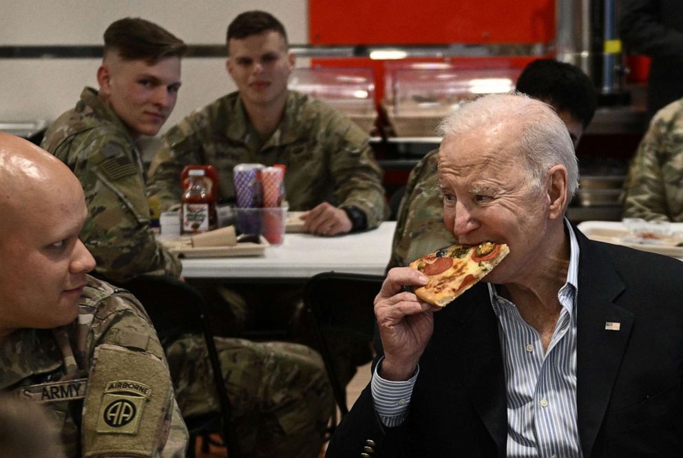 PHOTO: President Joe Biden eats a pizza slice as he meets with members of the 82nd Airborne Division in the city of Rzeszow in southeastern Poland, around 100 kilometres (62 miles) from the border with Ukraine, on March 25, 2022.