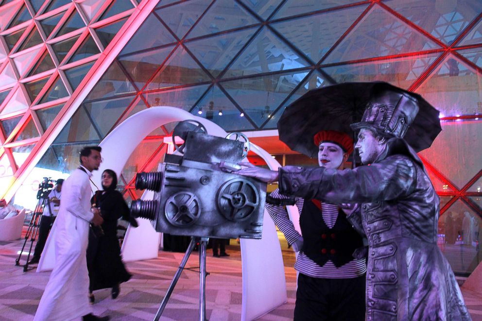 PHOTO: Two men in costume welcome visitors during the opening of the AMC Entertainment cinema theatre at the King Abdullah Financial District in Riyadh, Saudi Arabia, April 18, 2018.