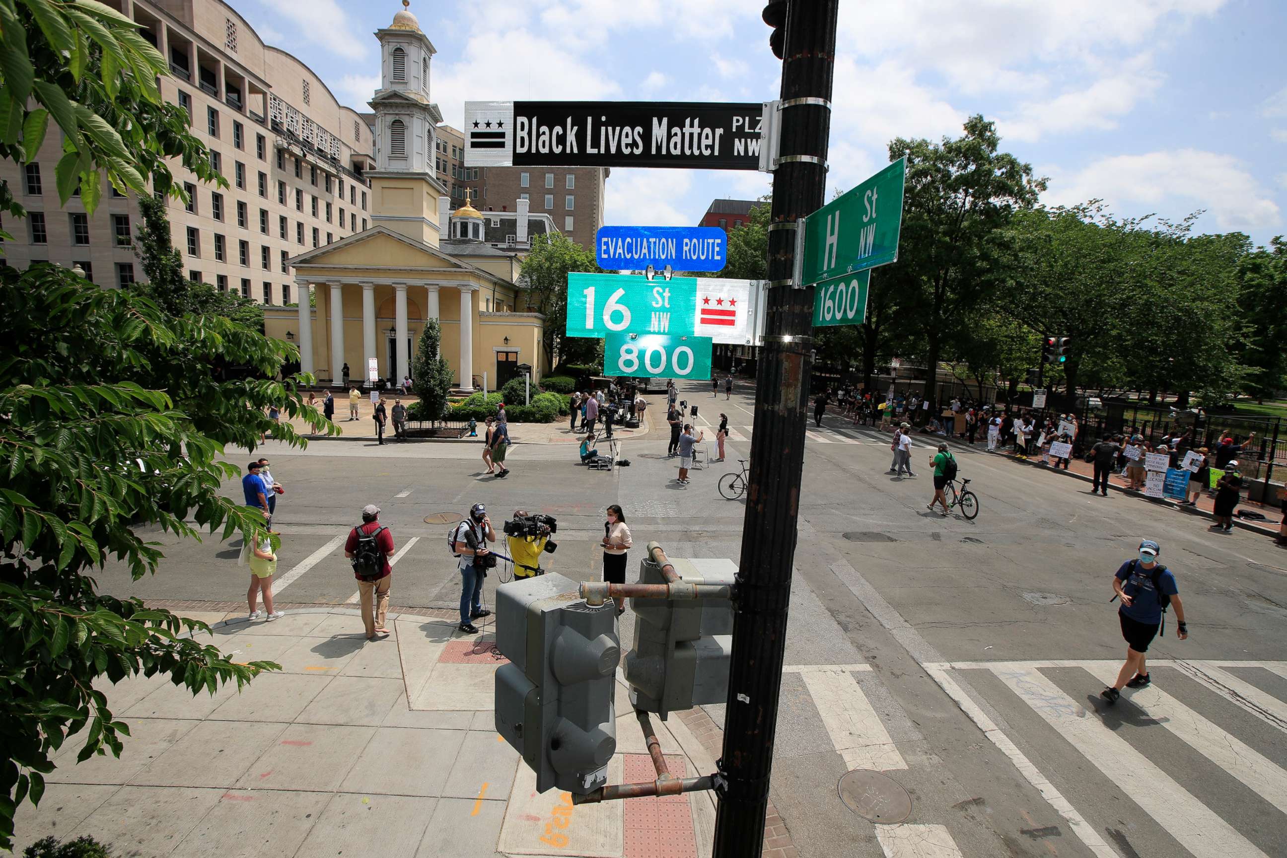 PHOTO: With St. John's Church in the background, people walk under a new street sign, June 5, 2020, in Washington.