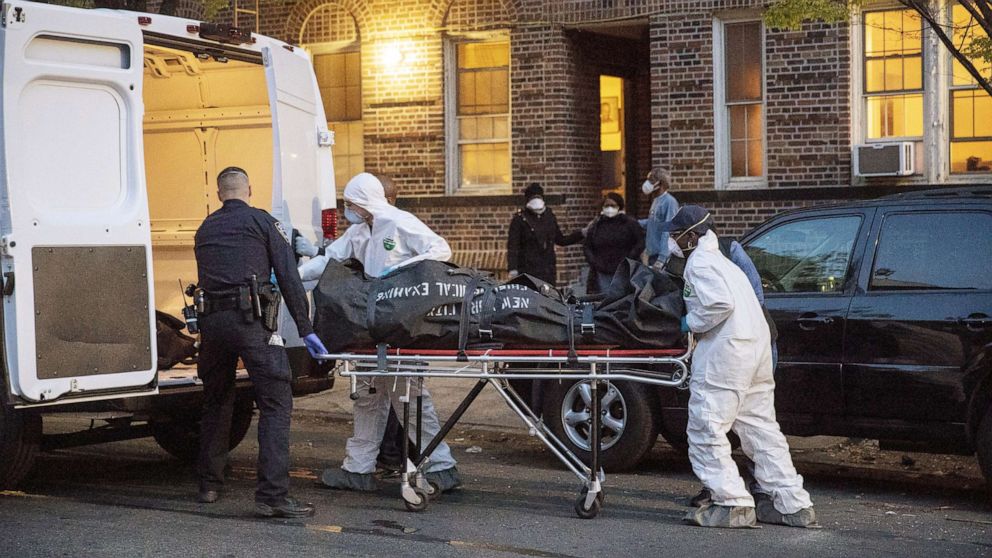 PHOTO: An officer from the New York Police Department helps workers carry a body out of a house amid the coronavirus disease (COVID-19) outbreak, in the Brooklyn borough of New York City, April 20, 2020.