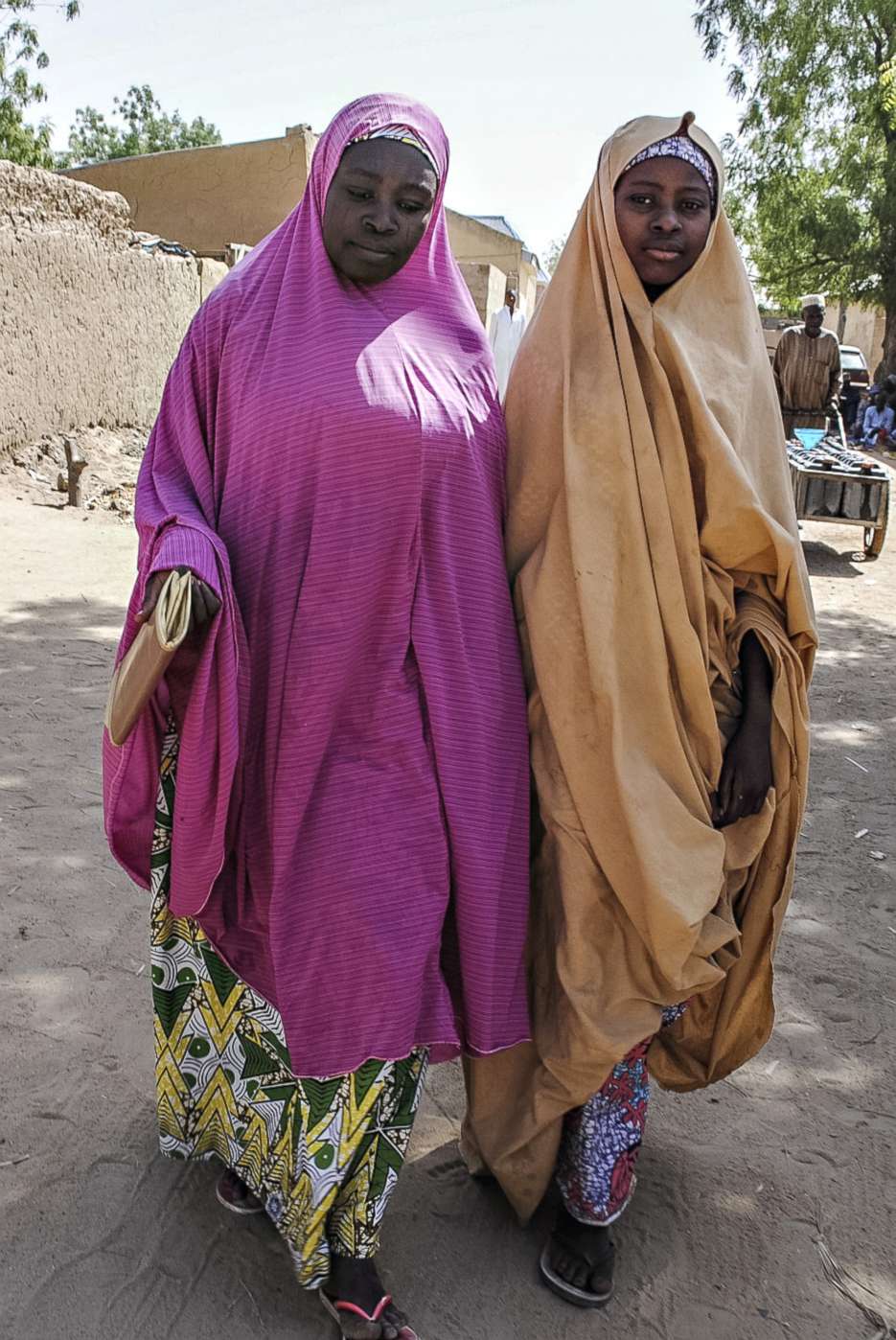 PHOTO: A girl, right, released by Boko Haram walks with her mother in Dapchi, Nigeria on March 21, 2018, after Boko Haram Islamists who kidnapped 110 schoolgirls  just over a month ago returned 101 of the students to the town, the government said. 