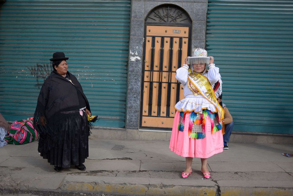 PHOTO: A traditional cholita observes her young daughter getting ready to dance at a preste celebration in La Paz, Bolivia, September 16, 2017.