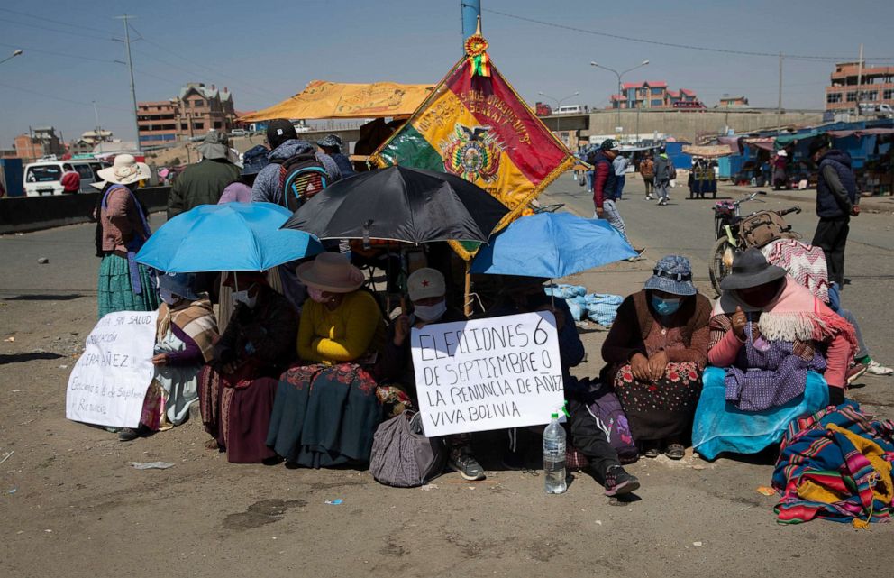 PHOTO: Women wearing face masks to prevent the spread of the novel coronavirus sit on the road in El Alto, Bolivia, on Aug. 3, 2020, to protest the postponement of the upcoming presidential election.