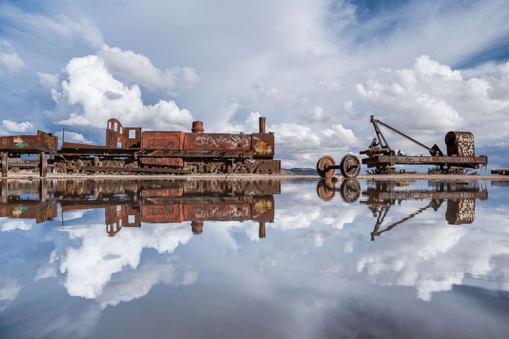 PHOTO: Clouds are perfectly reflected in the clear salt flats while a rusted train rests atop the vast flat in Salar de Uyuni, Bolivia, Jan. 31, 2014.