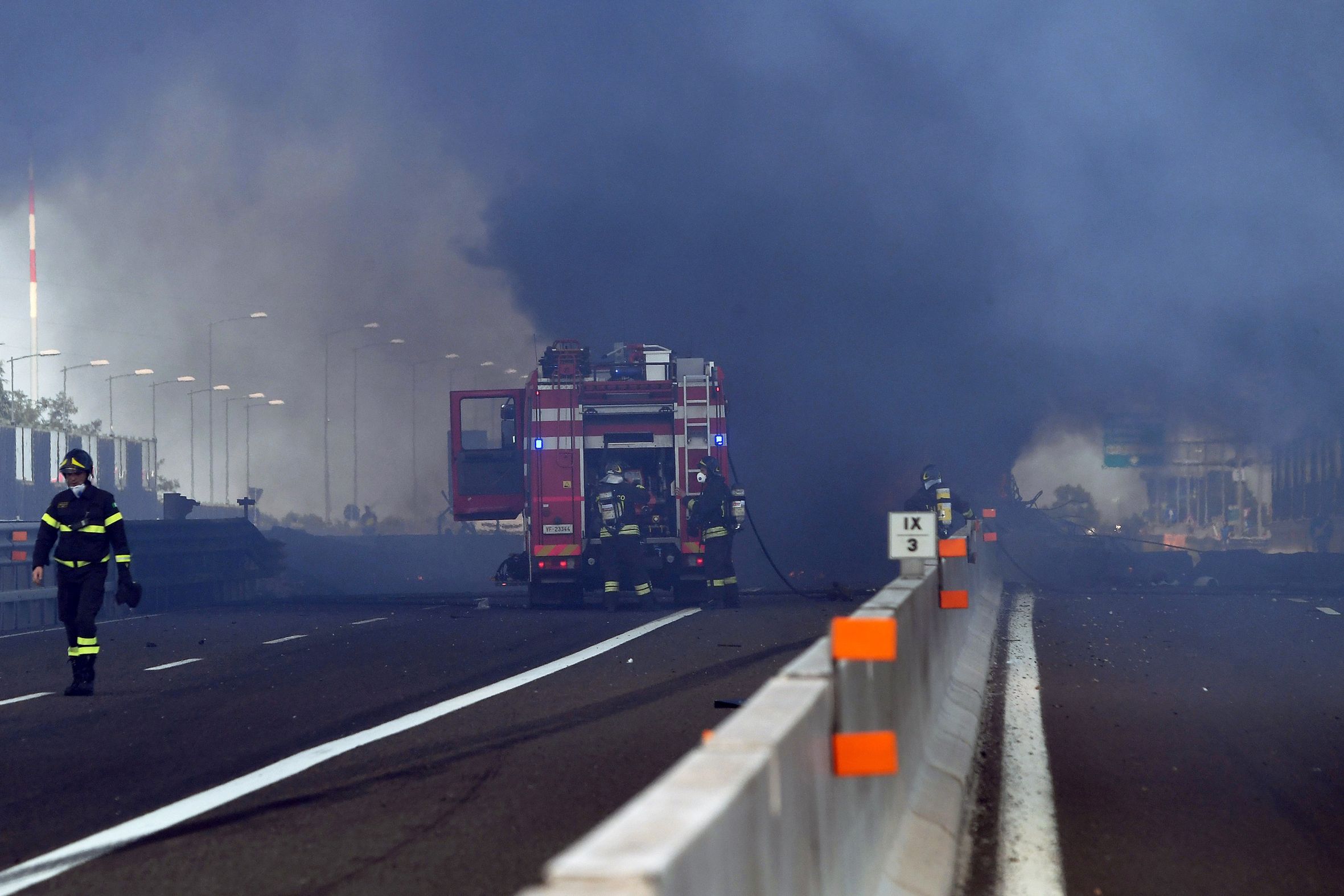 PHOTO: Firefighters work at the scene where a tanker truck exploded on a motorway just outside Bologna, northern Italy, on Aug. 6, 2018.
