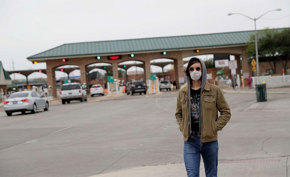 PHOTO: A pedestrian wears a protective mask as he passes the entrance to the McAllen Hidalgo International Bridge, March 21, 2020, in Hidalgo, Texas.