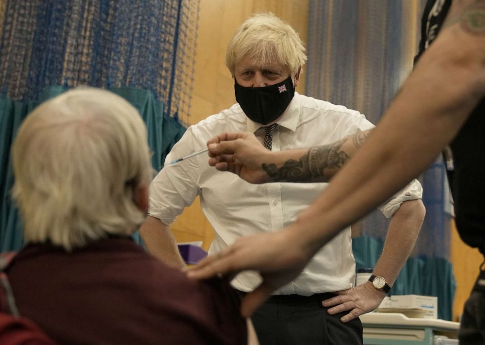PHOTO: Britain's Prime Minister Boris Johnson watches as Nitza Sarner, 88, receives a Pfizer booster vaccination during a visit to the COVID-19 vaccine centre, Oct. 22, 2021, in London.