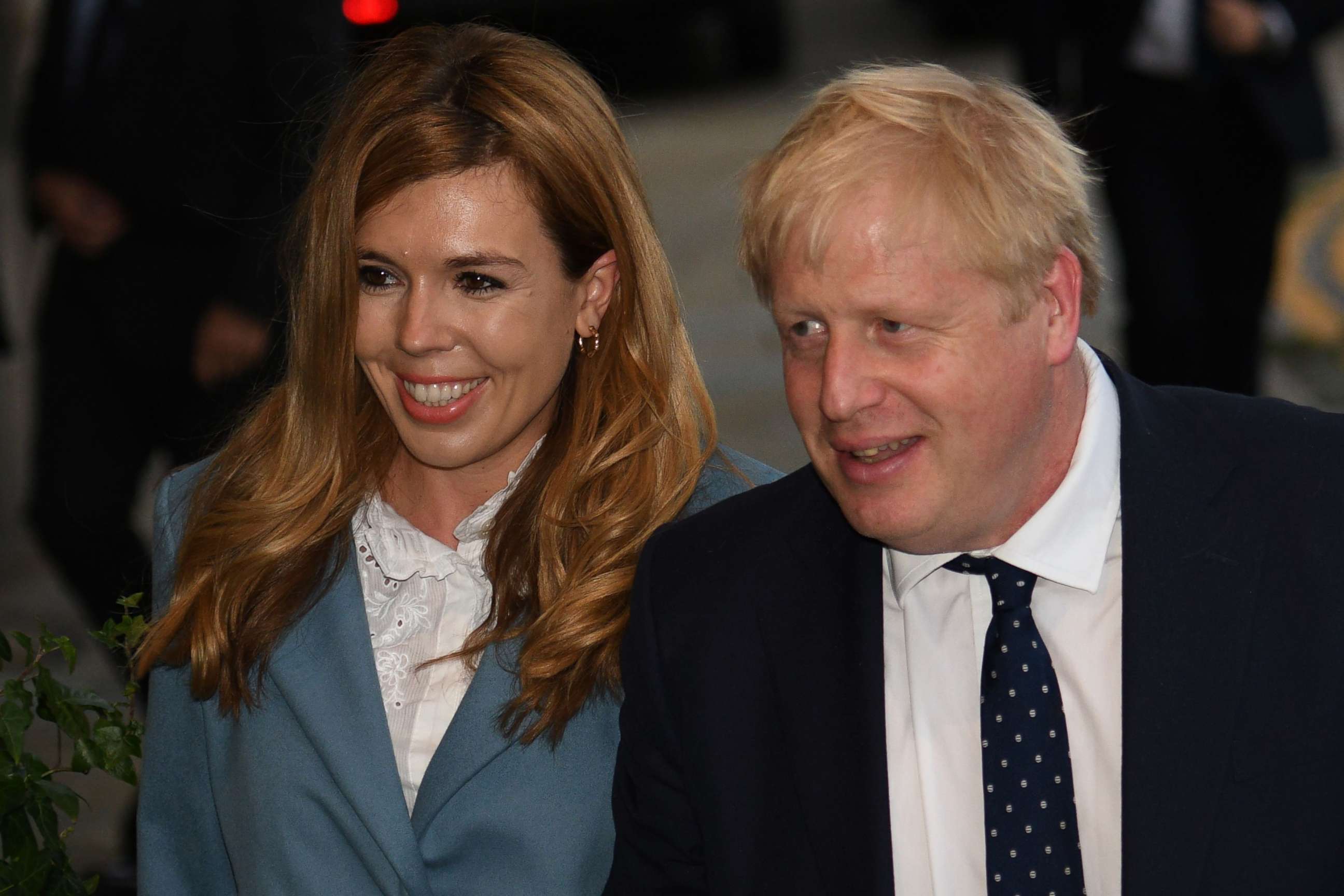 PHOTO: (FILES) In this file photo taken on September 28, 2019 Britain's Prime Minister Boris Johnson walks with his partner Carrie Symonds as they arrive at The Midland, near the Manchester Central convention complex in Manchester.