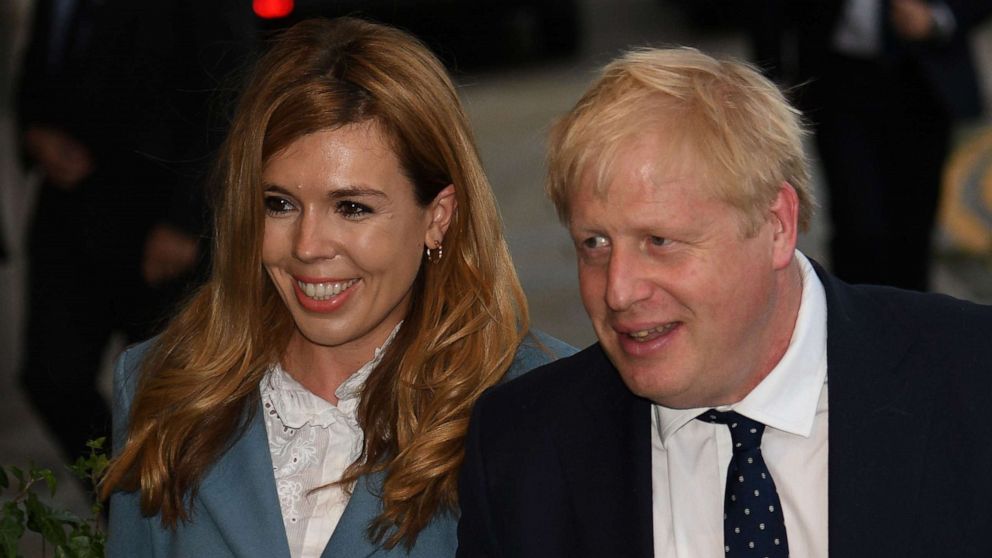 PHOTO: (FILES) In this file photo taken on September 28, 2019 Britain's Prime Minister Boris Johnson walks with his partner Carrie Symonds as they arrive at The Midland, near the Manchester Central convention complex in Manchester.