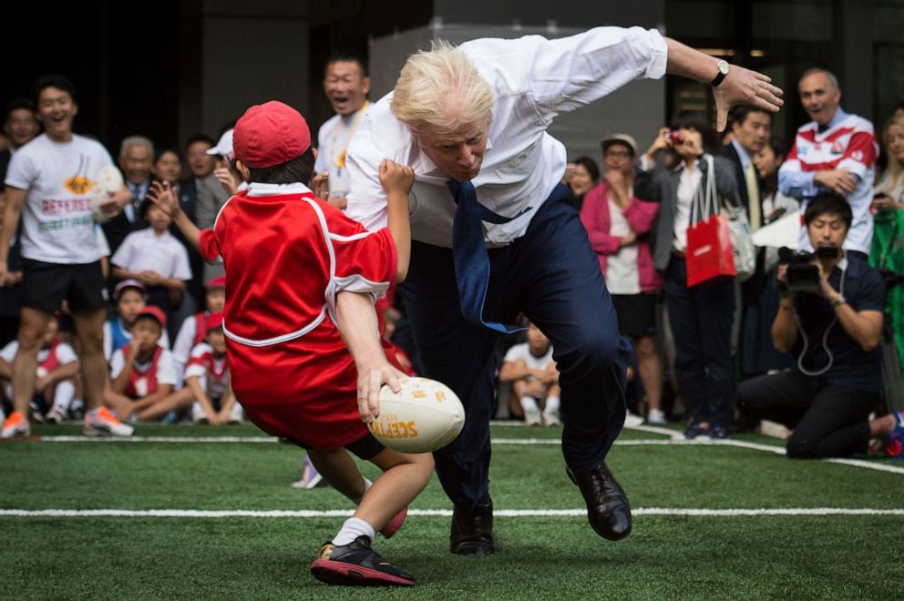 PHOTO: London Mayor Boris Johnson takes part in a game of rugby with children and adults on a street in Tokyo, Oct. 15, 2015, to mark Japan being chosen to host the 2019 Rugby World Cup.