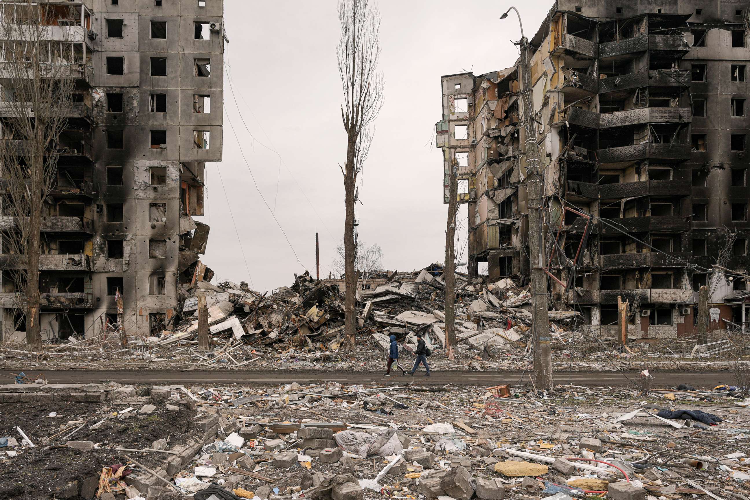 PHOTO: People walk by an apartment building destroyed during fighting between Ukrainian and Russian forces in Borodyanka, Ukraine, April 5, 2022.