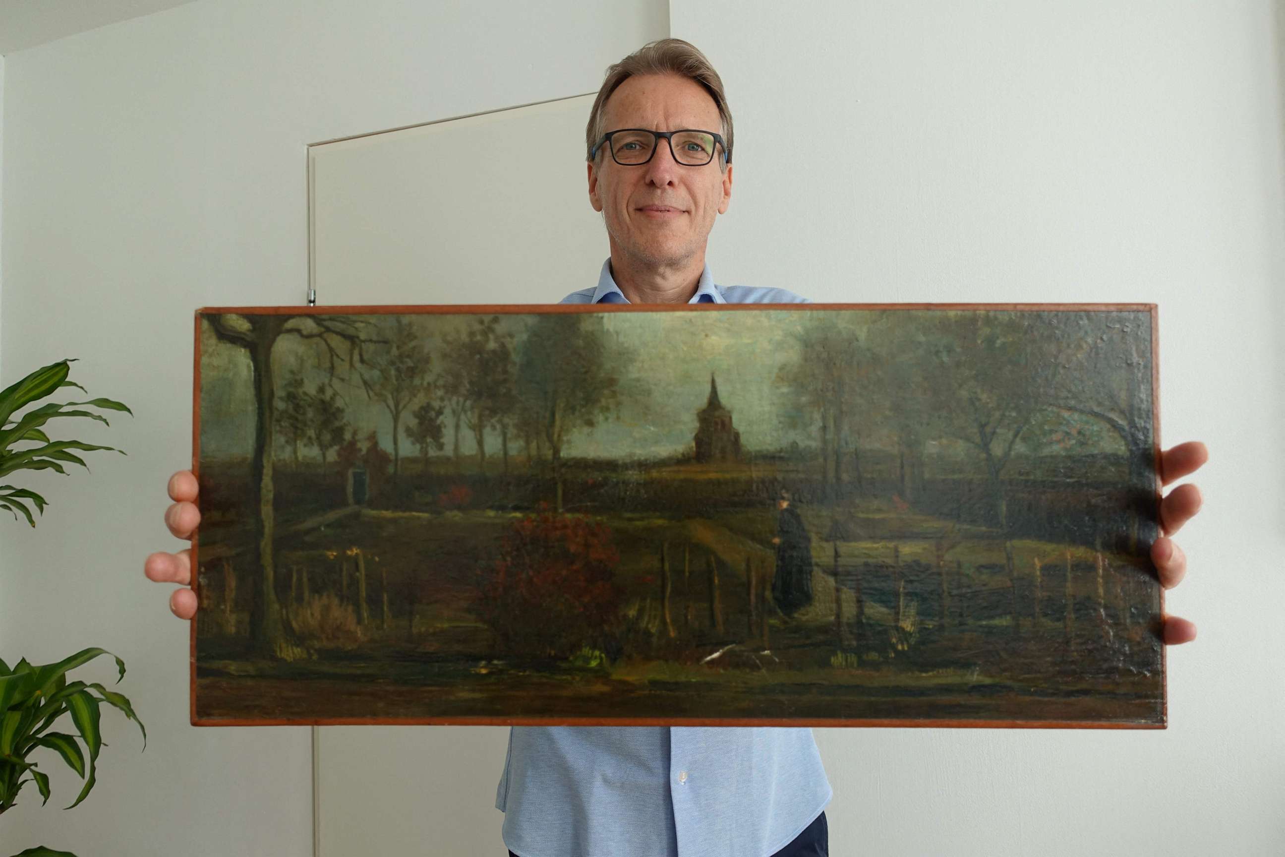 PHOTO: An handout picture released by Dutch art detective Arthur Brand shows a portrait of him posing with the painting title "Parsonage Garden at Nuenen in Spring", painted by Vincent van Gogh in 1884, at his home in Amsterdam on Sept. 11, 2023.