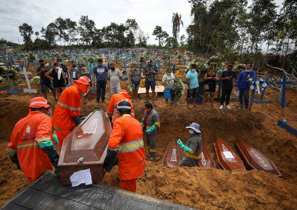 PHOTO: Gravediggers carry a coffin during a collective burial of people that have passed away due to COVID-19, at the Parque Taruma cemetery in Manaus, Brazil April 28, 2020. Picture taken April 28, 2020.
