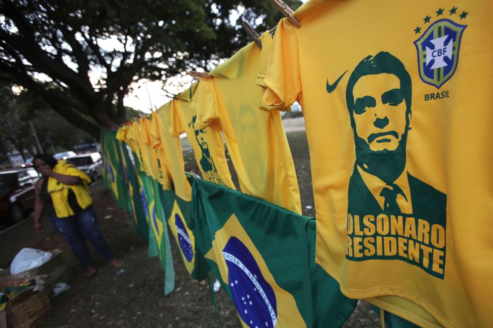 PHOTO: A woman sells T-shirts and flags with the image of presidential frontrunner Jair Bolsonaro of the Social Liberal Party, in front of the headquarters of the national congress, in Brasilia, Brazil, Oct. 7, 2018.