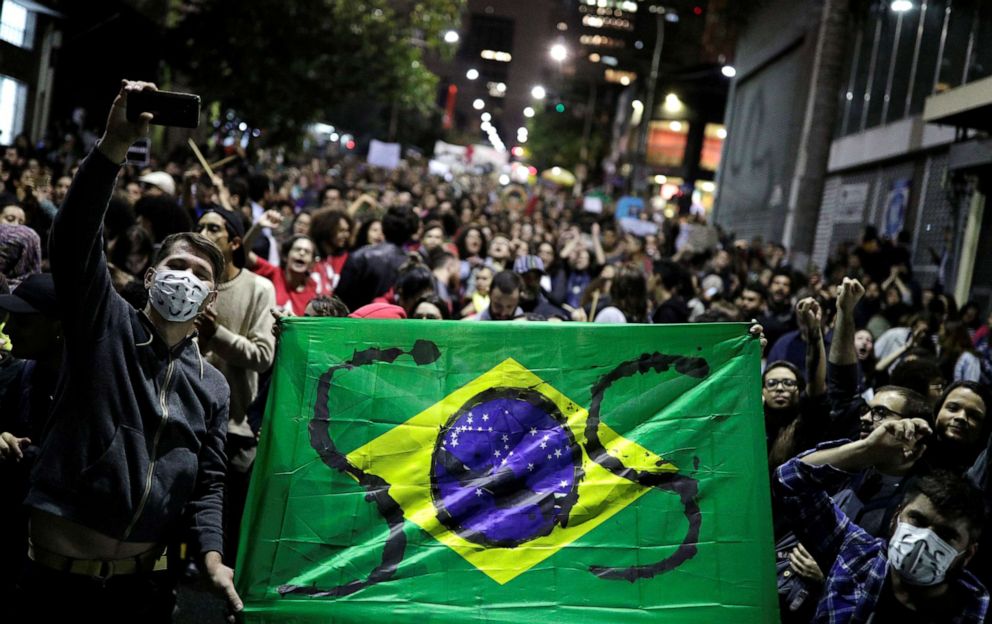 PHOTO: Protesters hold a Brazilian flag with the letters SOS written on it during a demonstration to demand for more protection for the Amazon rainforest, in Sao Paulo, Brazil, on Friday, Aug. 23, 2019.