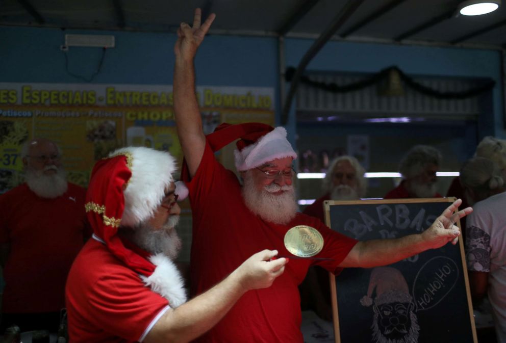 PHOTO: Carlos Alberto Patricio, a student of the Brazil's school of Santa Claus, receives his trophy during a ritual named "Barbas de Molho" to mark the end of Christmas season, in Rio de Janeiro, Dec. 26, 2018.