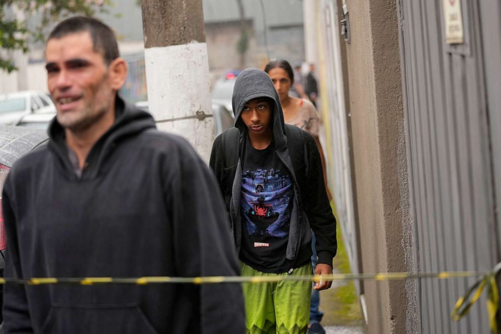 PHOTO: A student, center, leaves the Thomazia Montoro school with his father, left, after a fatal stabbing at the school in Sao Paulo, Brazil, March 27, 2023.