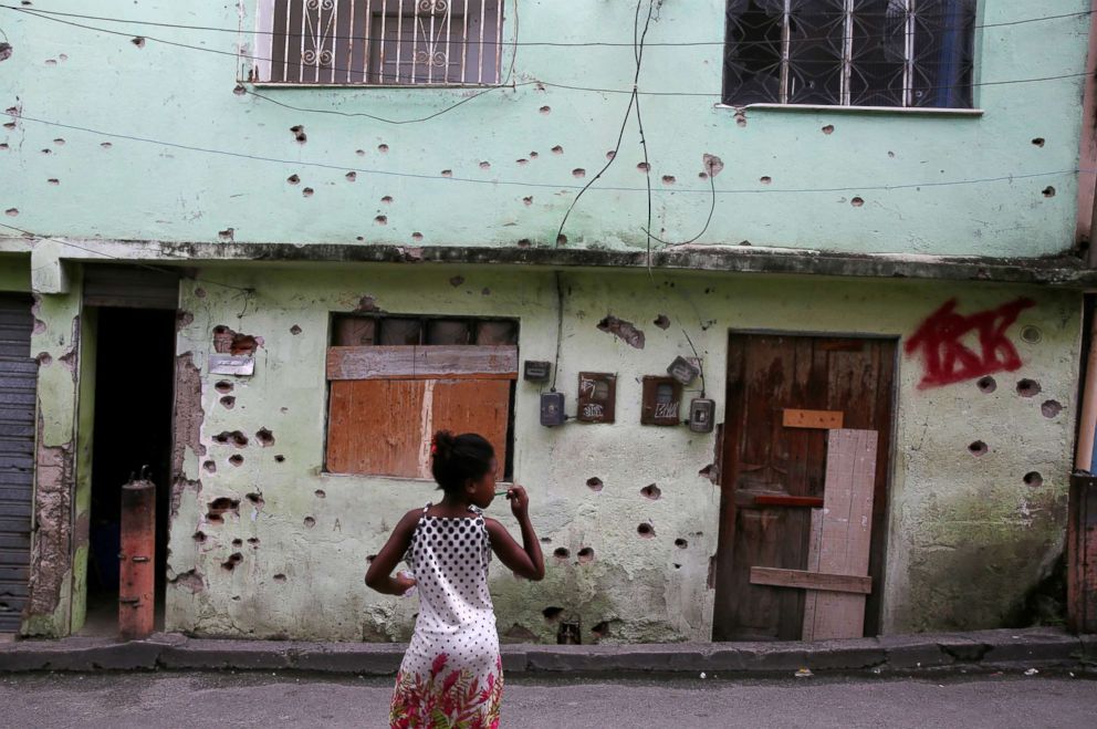 PHOTO: A girl stands in front of a house which is damaged by bullet holes in the Complexo de Alemao in Rio de Janeiro, Feb. 24, 2018.