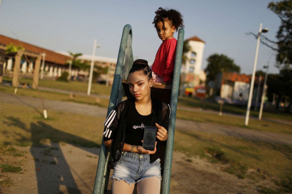 PHOTO: Eduarda Lopes, 12, poses for a photograph as she holds up a picture of her mother on her phone in Manguinhos in Rio de Janeiro, Sept. 13, 2018. Lopes's mother, Valdilene da Silva, was killed in crossfire as they walked together.