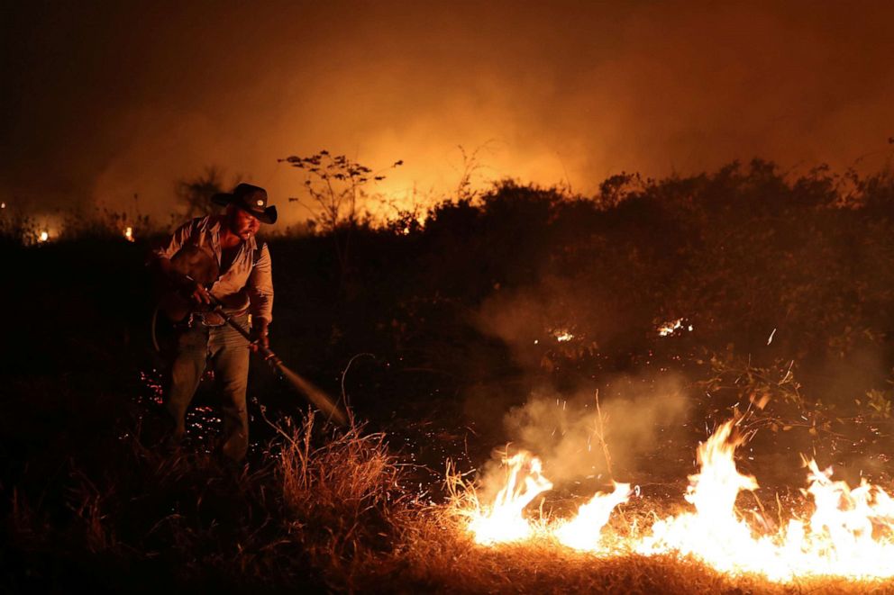 PHOTO: Sebastiao Baldi Silva Junior, 40, who works on a farm, attempts to put out a fire on a ranch in the Pantanal, the world's largest wetland, in Pocone, Mato Grosso state, Brazil, Aug. 26, 2020.