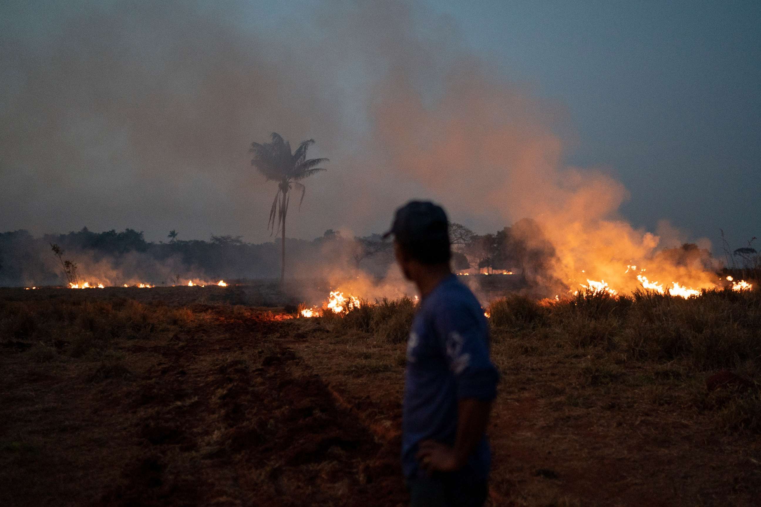 PHOTO: Neri dos Santos Silva watches an encroaching fire threat after digging trenches to keep the flames from spreading to the farm he works on, in the Nova Santa Helena municipality, in the state of Mato Grosso, Brazil, Friday, Aug. 23, 2019.