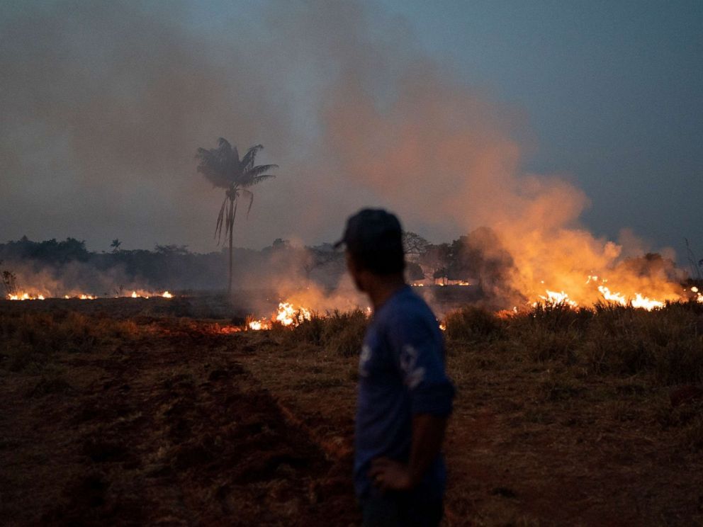 PHOTO: Neri dos Santos Silva watches an encroaching fire threat after digging trenches to keep the flames from spreading to the farm he works on, in the Nova Santa Helena municipality, in the state of Mato Grosso, Brazil, Friday, Aug. 23, 2019.