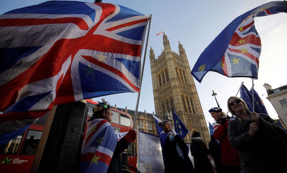 PHOTO: Anti-brexit campaigners wave Union and EU flags outside the Houses of Parliament in central London on Dec. 17, 2018, ahead of a statement by Britain's Prime Minister Theresa May.