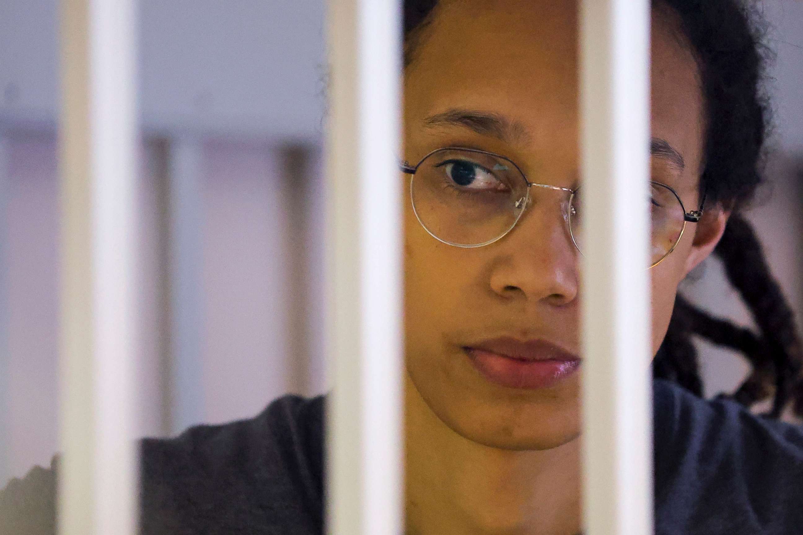 PHOTO: U.S. basketball player Brittney Griner looks through bars as she listens to the verdict standing in a cage in a courtroom in Khimki, outside Moscow, on Aug. 4, 2022.