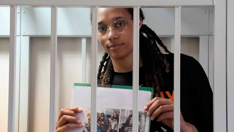 PHOTO: Olympian and WNBA basketball superstar Brittney Griner holds photographs standing inside a defendants' cage before a hearing at the Khimki Court, outside Moscow on July 27, 2022.
