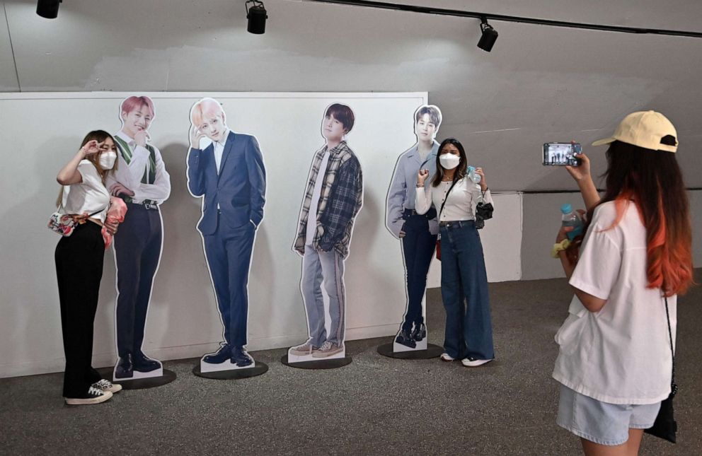 PHOTO: Visitors pose with card board cut outs of K-pop group BTS members for their souvenir photos at a tourist information centre in Seoul on June 15, 2022.