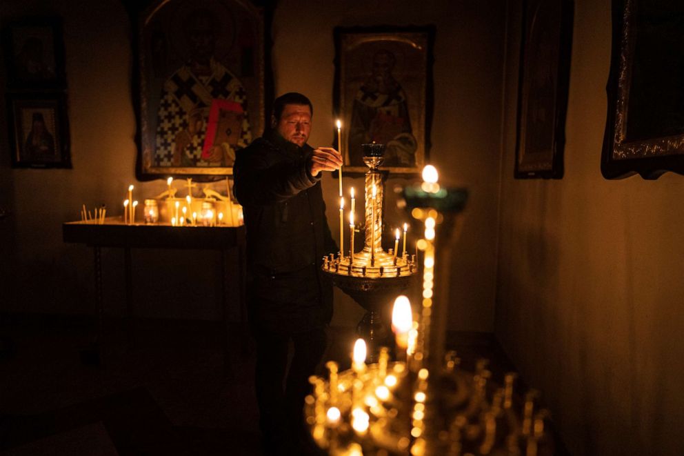 PHOTO: A man lights a candle during a Sunday service in an Orthodox church in Bucha, in the outskirts of Kyiv, Ukraine, April 10, 2022.