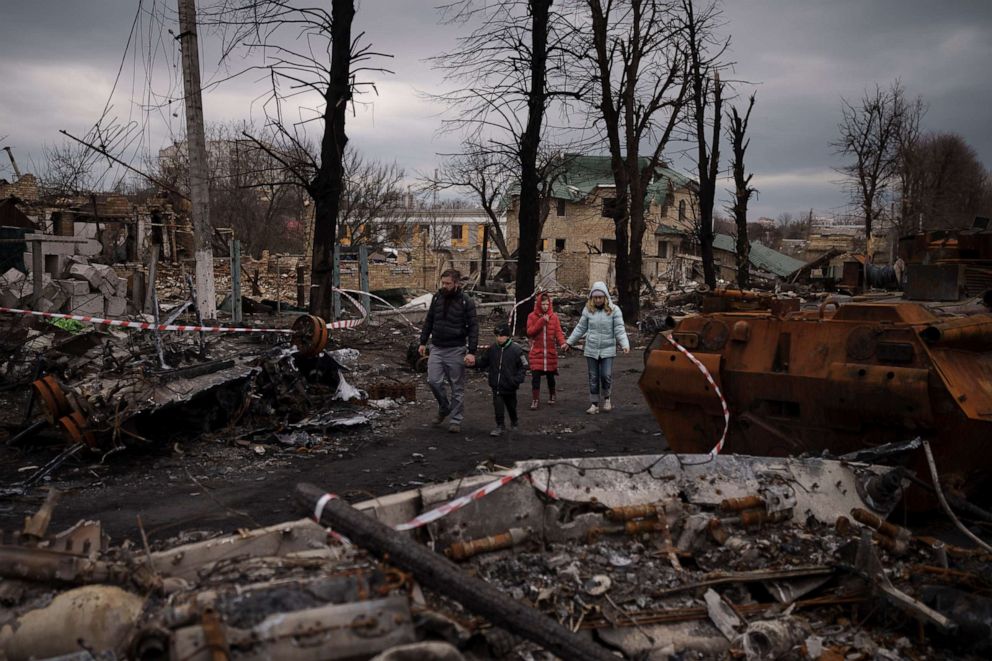 PHOTO: A family walks amid destroyed Russian tanks in Bucha, northwest of Kyiv, Ukraine, on April 6, 2022.