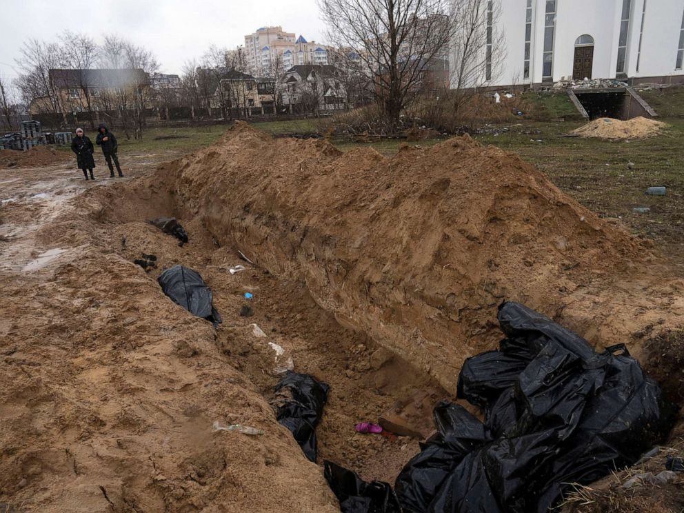 PHOTO: Neighbors gather next to a mass grave near the Church of St. Andrew and Pyervozvannoho All Saints in Bucha, on the outskirts of Kyiv, Ukraine, April 3, 2022.