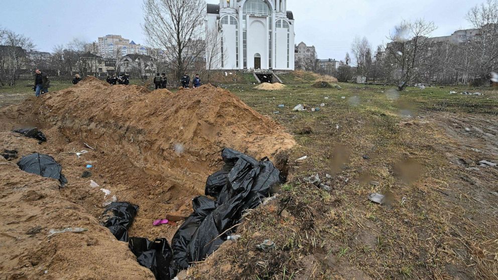 PHOTO: A mass grave is seen behind the Church of St. Andrew and Pyervozvannoho All Saints in the town of Bucha, northwest of the Ukrainian capital Kyiv on April 3, 2022.