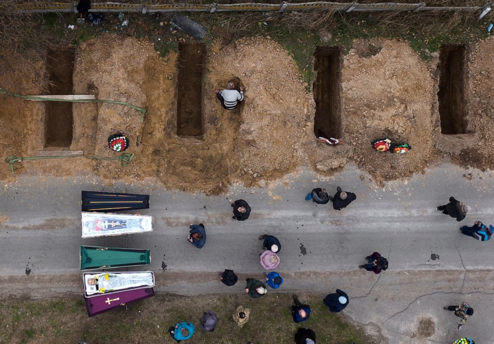 The bodies of four people who died during the Russian occupation await burial in Bucha, on the outskirts of Kyiv, April 20, 2022. Amnesty International said Friday, May 6, 2022, it has documented extensive war crimes by Russian forces around Kyiv,