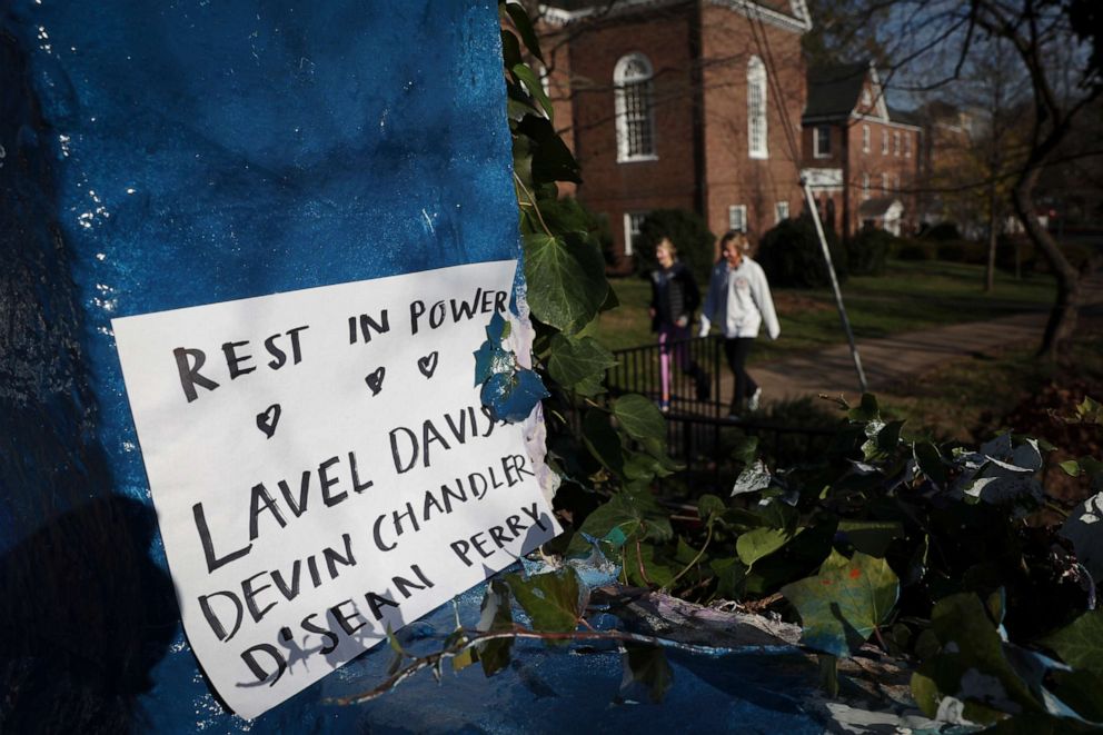 PHOTO: Students walk past a sign memorializing three University of Virginia football players killed during an overnight shooting at the university, Nov. 14, 2022, in Charlottesville, Va.