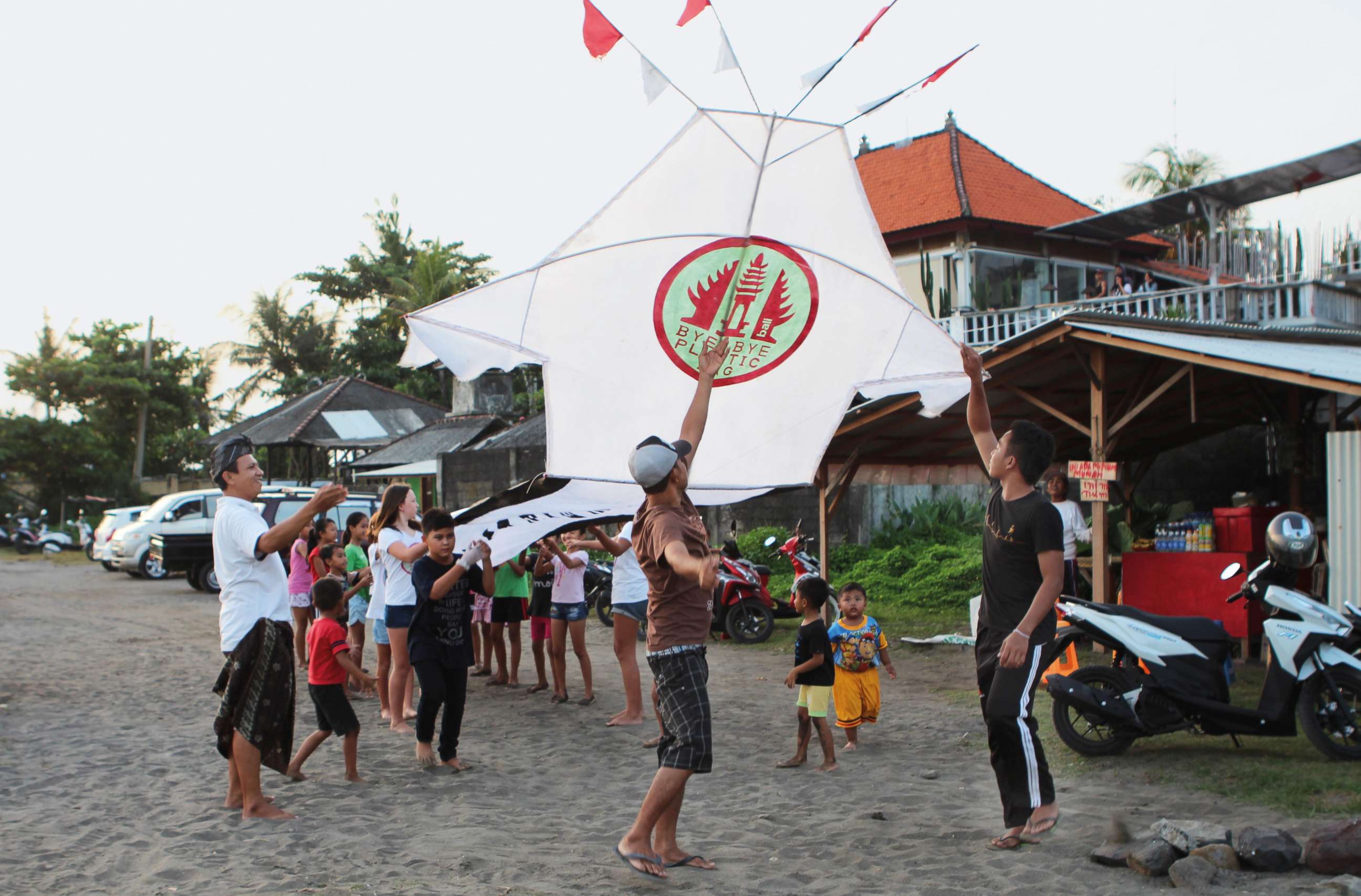 PHOTO: Girls and boys from the project's pilot village, Pererenan, help fly a giant kite carrying the Bye Bye Plastic Bags logo, to increase awareness, Bali, Indonesia.