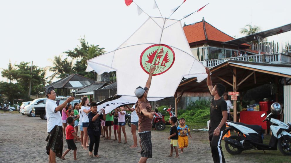 PHOTO: Girls and boys from the project's pilot village, Pererenan, help fly a giant kite carrying the Bye Bye Plastic Bags logo, to increase awareness, Bali, Indonesia.