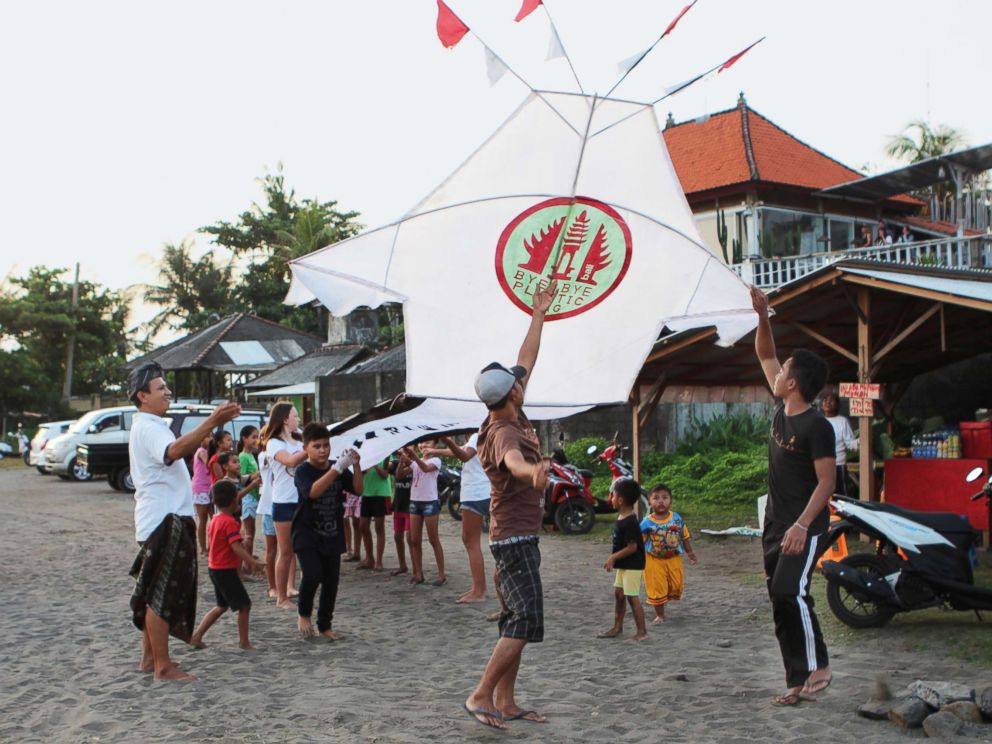 PHOTO: Girls and boys from the projects pilot village, Pererenan, help fly a giant kite carrying the Bye Bye Plastic Bags logo, to increase awareness, Bali, Indonesia.