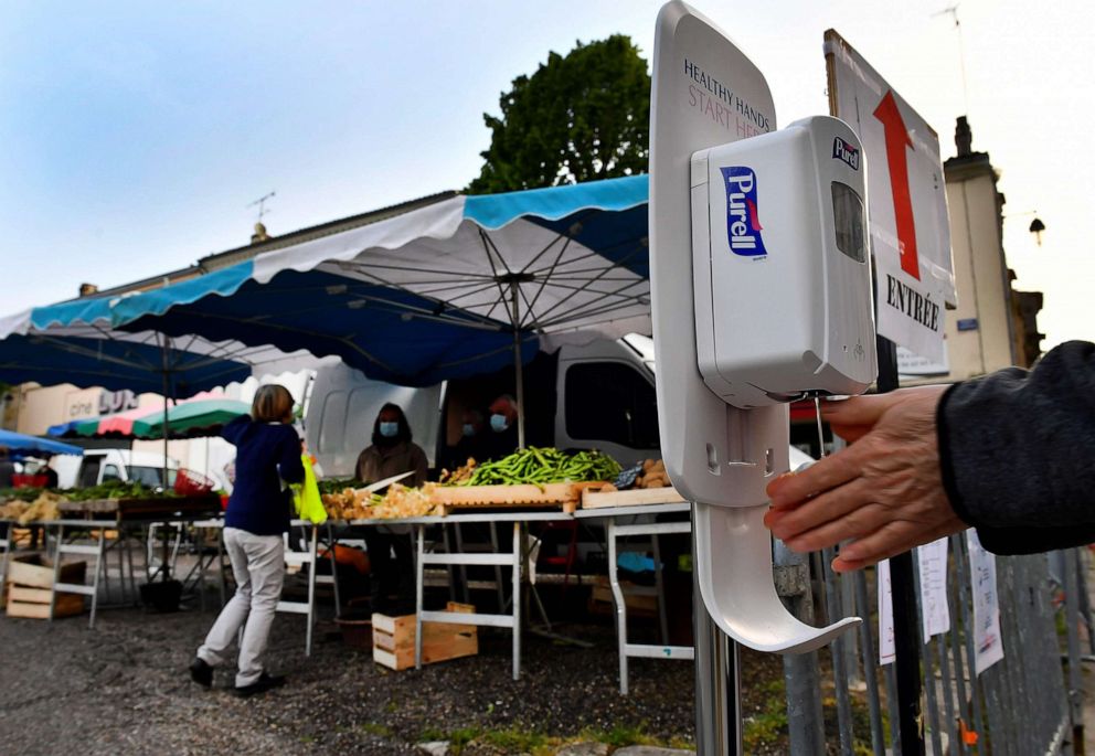 PHOTO: A shopper uses a sanitizer dispenser prior to entering the Cadillac market near the southwestern city of Bordeaux, France, on April 25, 2020.